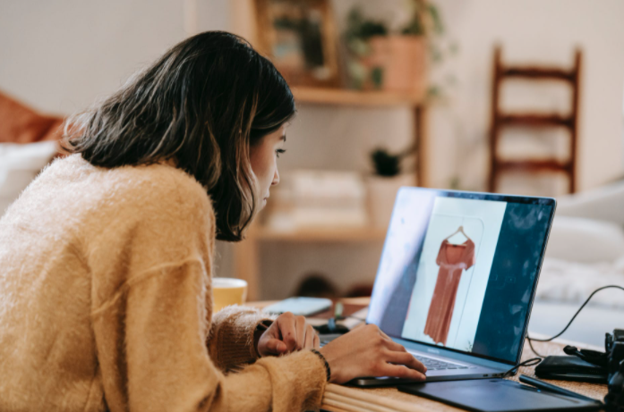 Ethnic freelancer working on laptop with photo on screen